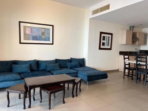 a living room with a blue couch and a table at EP4 Samarah Resort in Sowayma