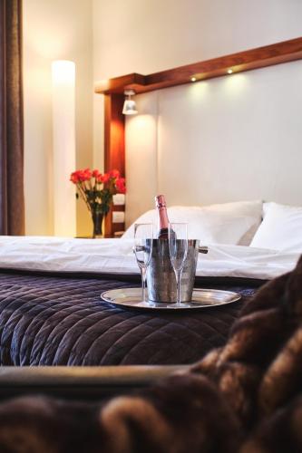a table with two glasses and a bottle on a bed at Hotel on the Promenade in Cape Town