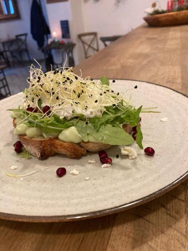 a white plate with a sandwich on a table at Time Cafe & Penzion in Příbram