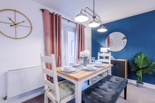 ein Esszimmer mit einem Tisch und einer Uhr in der Unterkunft Beautiful Stoke Home Sleeps 10 by PureStay Short Lets in Stoke on Trent