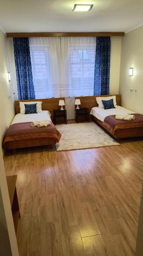 a bedroom with two beds and a large window at Apart Hotel Sutoris in Bochnia