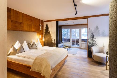 a bedroom with a large bed and a large window at Landhotel Schermer in Westendorf