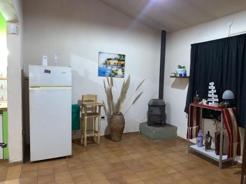 a living room with a white refrigerator and a stove at Chalet MAX in Bialet Massé