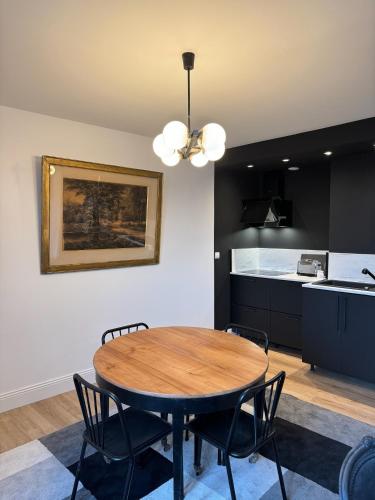 une table de salle à manger avec des chaises et une cuisine dans l'établissement Le 28 - Résidence de Standing en Vieille-ville avec Parking, à Boulogne-sur-Mer