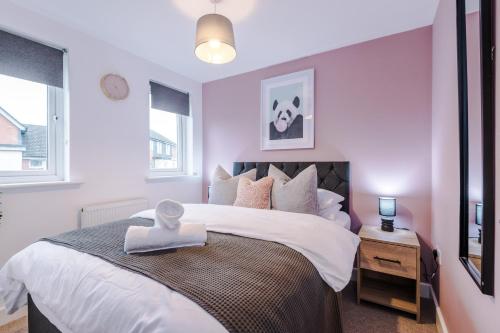 a bedroom with a large bed with a towel on it at Beautiful Stoke Home Sleeps 10 by PureStay Short Lets in Stoke on Trent