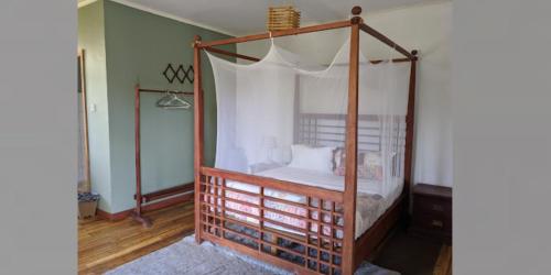 a bedroom with a canopy bed with white sheets at Sunrise Motel in Lilongwe