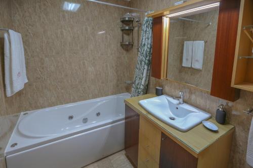 een badkamer met een bad, een wastafel en een bad bij Aromas Flavors Tours Esmoriz Beach in Esmoriz