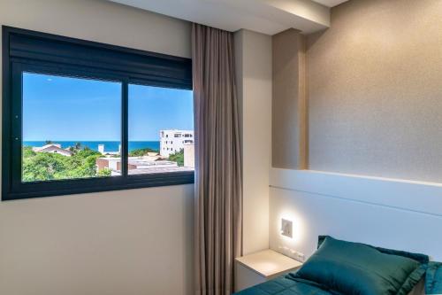 Schlafzimmer mit einem Fenster mit Meerblick in der Unterkunft Paradise 205 - Cobertura 2 suítes com vista para o mar de dentro e mar de fora na praia do Canto Grande in Bombinhas