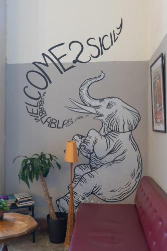a mural of a bear on a wall with a sign at Ostello degli Elefanti in Catania