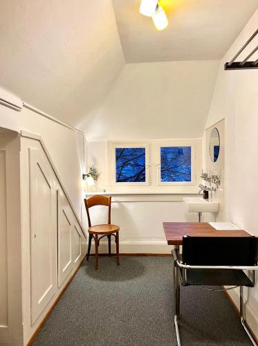ein Badezimmer mit einem Tisch, einem Stuhl und einem Waschbecken in der Unterkunft Villa Bergruh in St. Gallen
