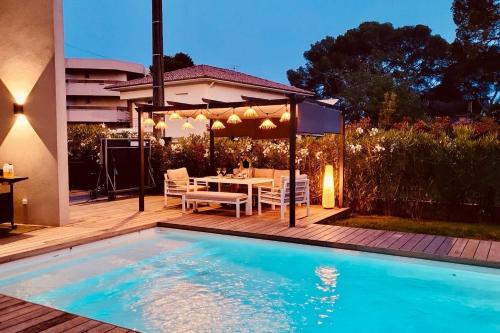une arrière-cour avec une piscine, une table et une maison dans l'établissement Magnifique Villa contemporaine climatisé piscine Ref Villa Notre Dame, à Saint-Raphaël
