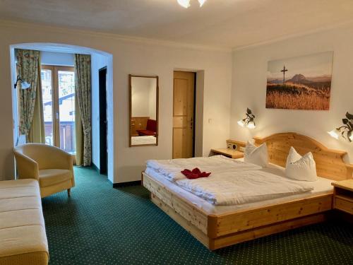 a hotel room with a bed and a chair at Hotel Metzgerwirt in Kirchberg in Tirol