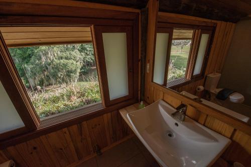 Un baño con lavabo y dos ventanas. en Monã, en Canela