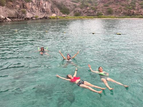 a group of people swimming in the water at Casa rodante los cachorones in Loreto
