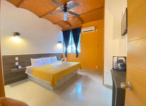 a bedroom with a bed with a ceiling fan at MarySol Las Palmas in Rincon de Guayabitos