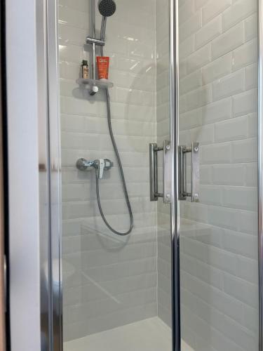d'une douche avec une porte en verre et un pommeau de douche. dans l'établissement Clos Manila, à La Seyne-sur-Mer