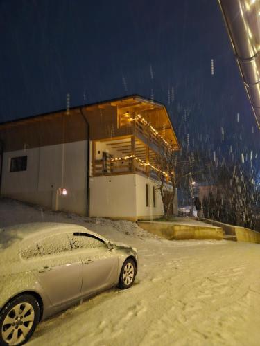 a car parked in the snow in front of a building at Casa Mara Viseu de Sus in Vişeu de Sus