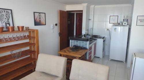 eine Küche mit einem Kühlschrank sowie einem Tisch und Stühlen in der Unterkunft Apartamento Único! in Conde