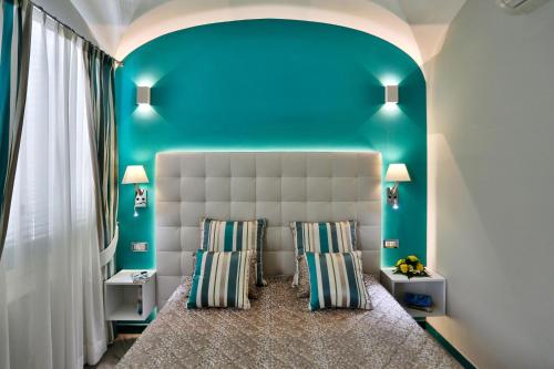 1 dormitorio con 1 cama con pared azul en Amalfi Apartments Design centro storico, en Amalfi