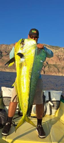 a man holding a large fish on a boat at Casa rodante los cachorones in Loreto