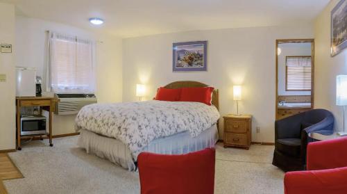 1 dormitorio con cama, escritorio y silla en Green Springs Inn en Ashland