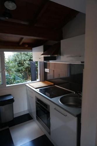 une petite cuisine avec un évier et une cuisinière dans l'établissement Grand studio de 30m2 !central !spacieux !différent !, à Cannes
