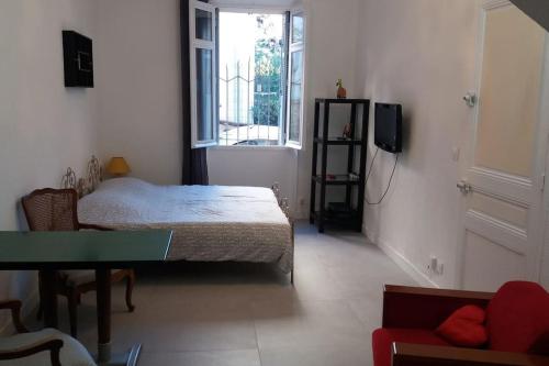une chambre avec un lit et une télévision dans une pièce dans l'établissement Grand studio de 30m2 !central !spacieux !différent !, à Cannes
