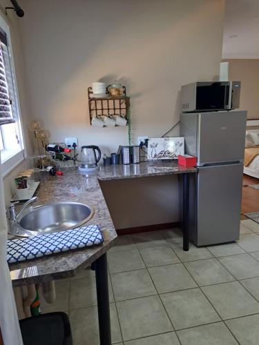 La cuisine est équipée d'un évier et d'un réfrigérateur. dans l'établissement Comfy & Cozy @ 26 Chopin, à Potchefstroom