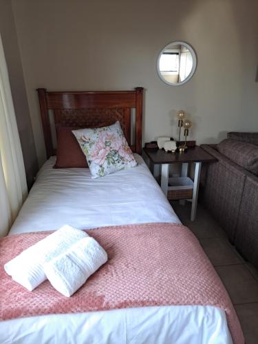 - une chambre avec un lit et une table avec un canapé dans l'établissement Comfy & Cozy @ 26 Chopin, à Potchefstroom