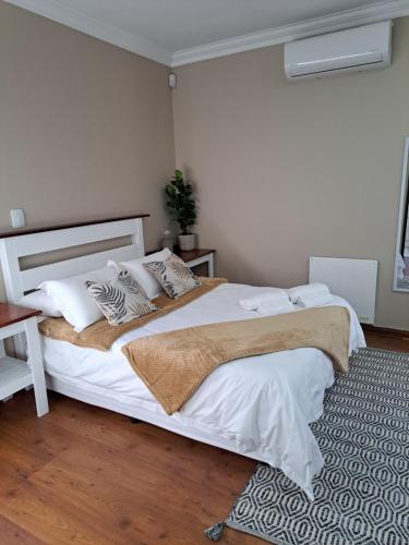 - une chambre dotée d'un grand lit avec des draps et des oreillers blancs dans l'établissement Comfy & Cozy @ 26 Chopin, à Potchefstroom