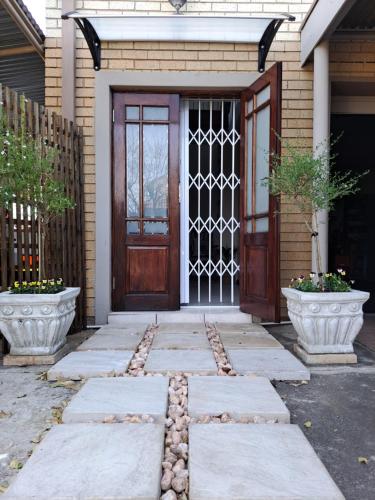 une porte d'entrée d'une maison avec deux vases dans l'établissement Comfy & Cozy @ 26 Chopin, à Potchefstroom