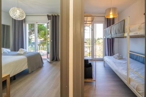 1 Schlafzimmer mit 2 Etagenbetten und einem Balkon in der Unterkunft La Maison Snoopy, 6-8 persons, near beach, seaview in Lloret de Mar