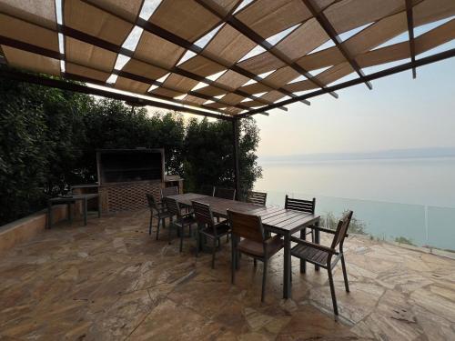 a wooden table and chairs on a patio with a view at E25 TWO BEDROOM APARTMENT AT Samarah Resort in Sowayma