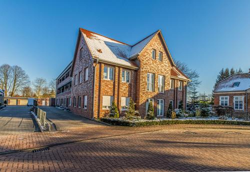un grand bâtiment en briques sur une route en briques dans l'établissement Küstenhaus, à Esens