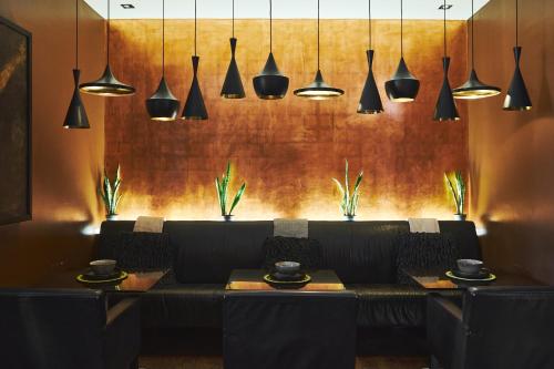 a dining room with a bench and pendant lights at Hotel on the Promenade in Cape Town