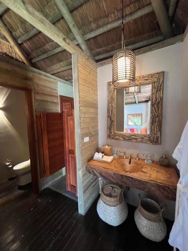 a bathroom with a large sink and a mirror at ACASI Rustic Beach in Baru