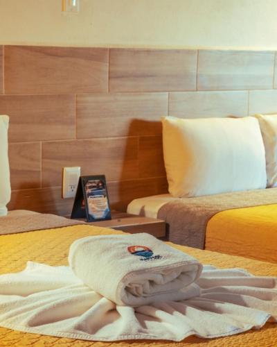 a hotel room with a towel on a bed at MarySol Las Palmas in Rincon de Guayabitos