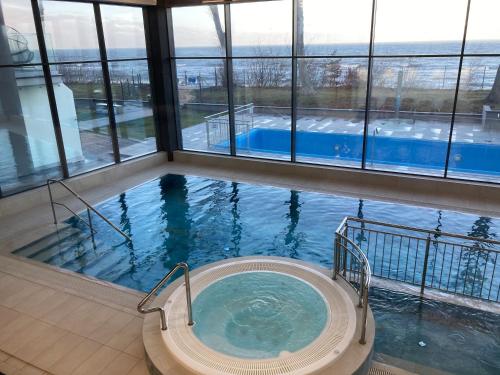 a bath tub in a building with a swimming pool at Apartament Holiday Mini On The Cliff in Rewal
