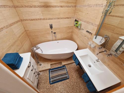 a bathroom with a large tub and a sink at Quiet spacious apartment with a balcony in Prague