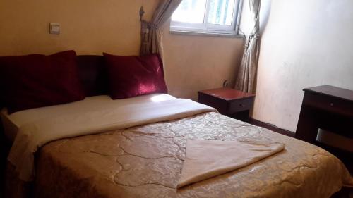 a bedroom with a large bed with a window at 70 Dereja Hotel in Addis Ababa