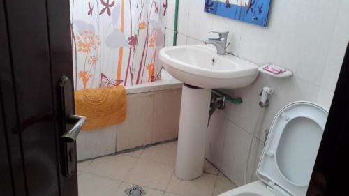 La salle de bains est pourvue d'un lavabo et de toilettes. dans l'établissement 70 Dereja Hotel, à Addis-Abeba