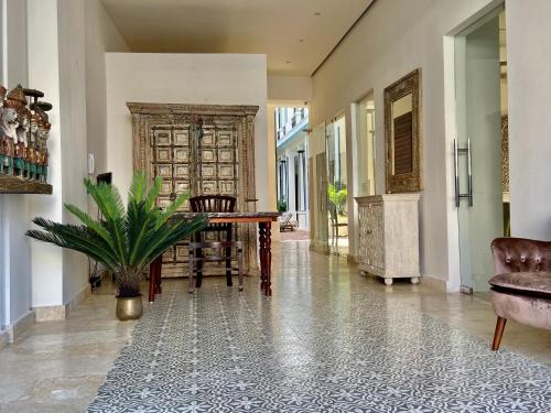 un pasillo con mesa, sillas y una planta en Boutique Hotel Casa Grande, en Santo Domingo