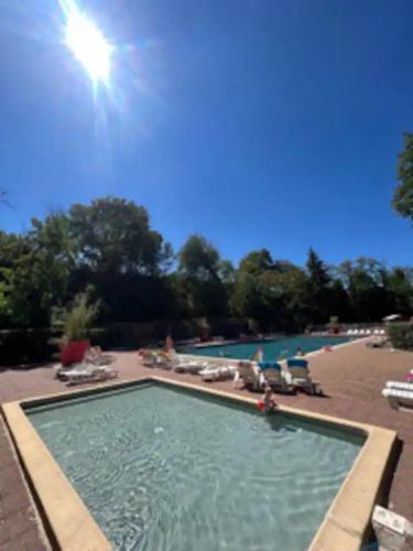 a large swimming pool with chairs and a sunvisor at La maison du Sud in Saint-Chéron