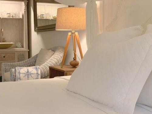 ein Schlafzimmer mit einem Bett mit einer Lampe und einem Stuhl in der Unterkunft Monte Sagrado Reserve - wellnessTanama Riverfarm cabin in Quebrada