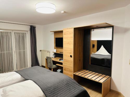 een slaapkamer met een bed en een bureau met een bureau bij Bold´S Hotel-Restaurant "Zum Grünen Kranz" in Rodalben