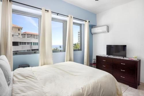 - une chambre avec un lit et une grande fenêtre dans l'établissement soundproof windows over Condado Beach, San Juan apts, à San Juan