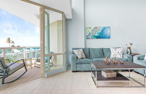 uma sala de estar com um sofá e uma mesa em Ocean View Penthouse with pool, beachfront complex apts em Río Grande