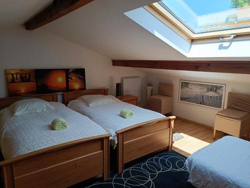 1 dormitorio con 2 camas individuales y tragaluz en Près golfs et plages piscine chauffée, en Bidart