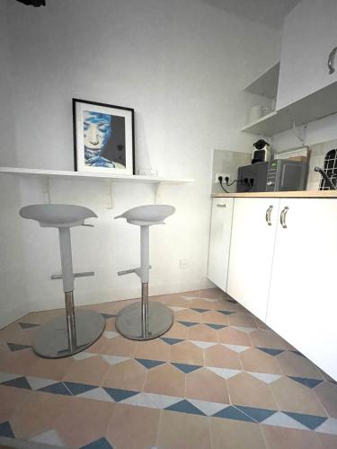 une cuisine avec un comptoir et deux tabourets à un étage dans l'établissement Dans le triangle d’Or de Boulogne, à Boulogne-Billancourt