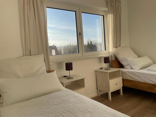 1 dormitorio con 2 camas y ventana en Ferienwohnung am Hirschbach en Herbrechtingen